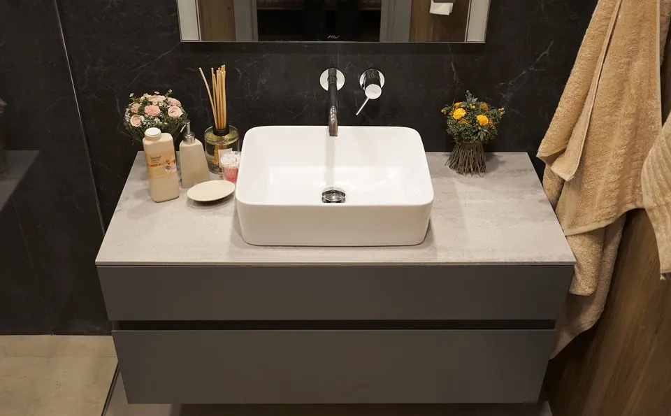 Wall-hung vanity with a grey solid surface top and square vessel basin