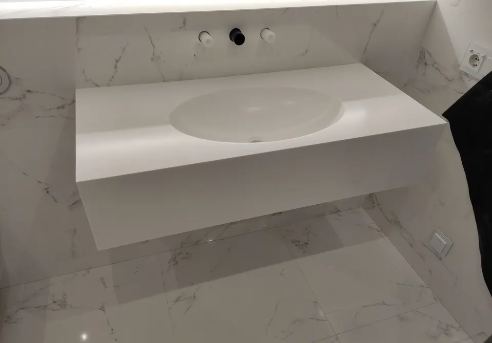 Wall-hung white solid surface washbasin with integrated bowl