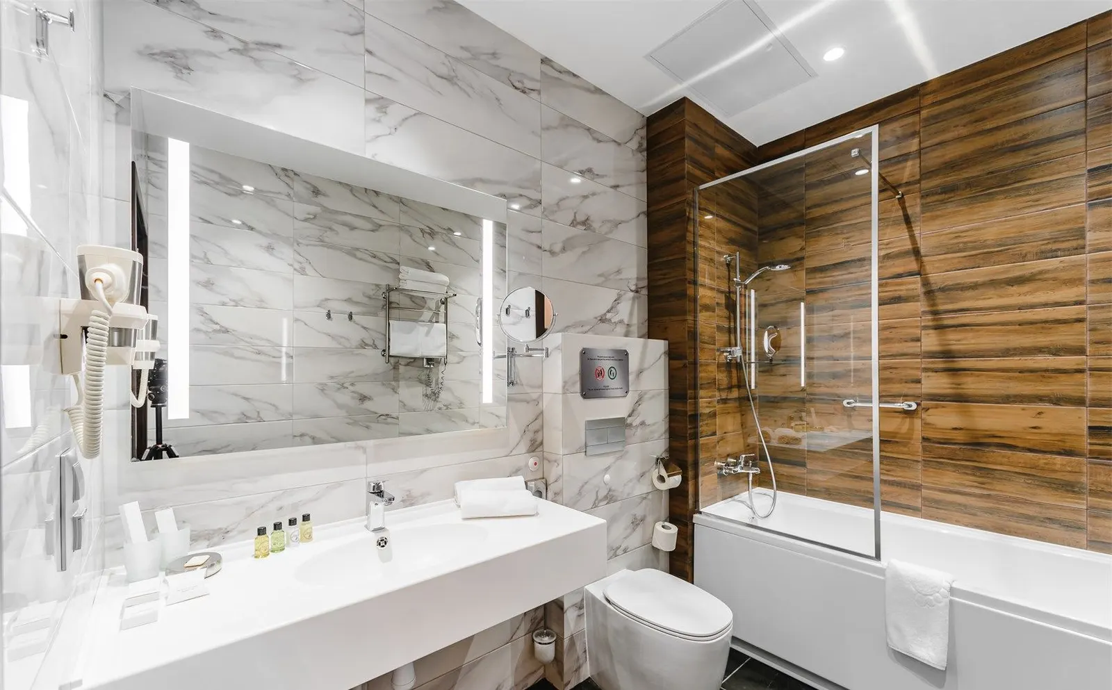 Hotel guest bathroom with a long white solid surface vanity top and integrated basin