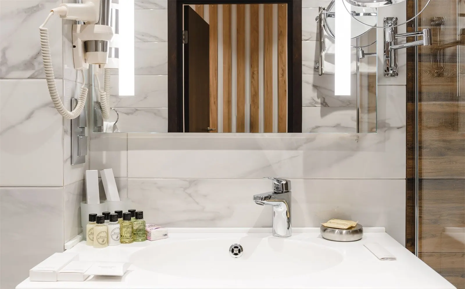 Close view of a white solid surface integrated washbasin with hotel amenities