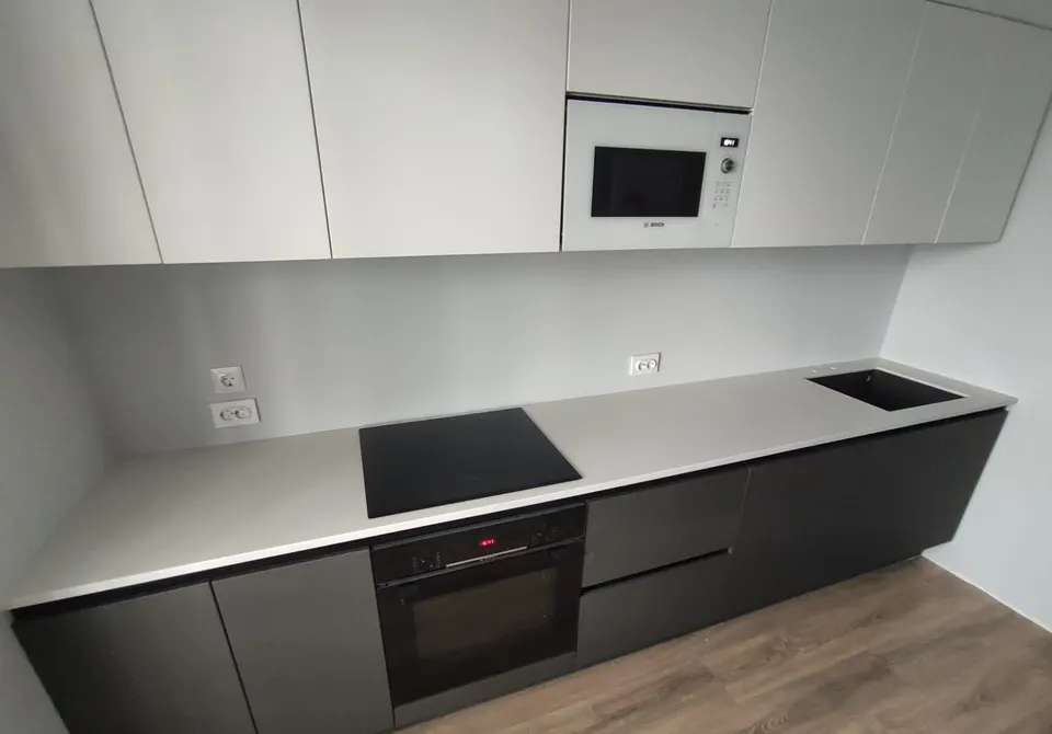 Grey solid surface kitchen worktop on dark base units