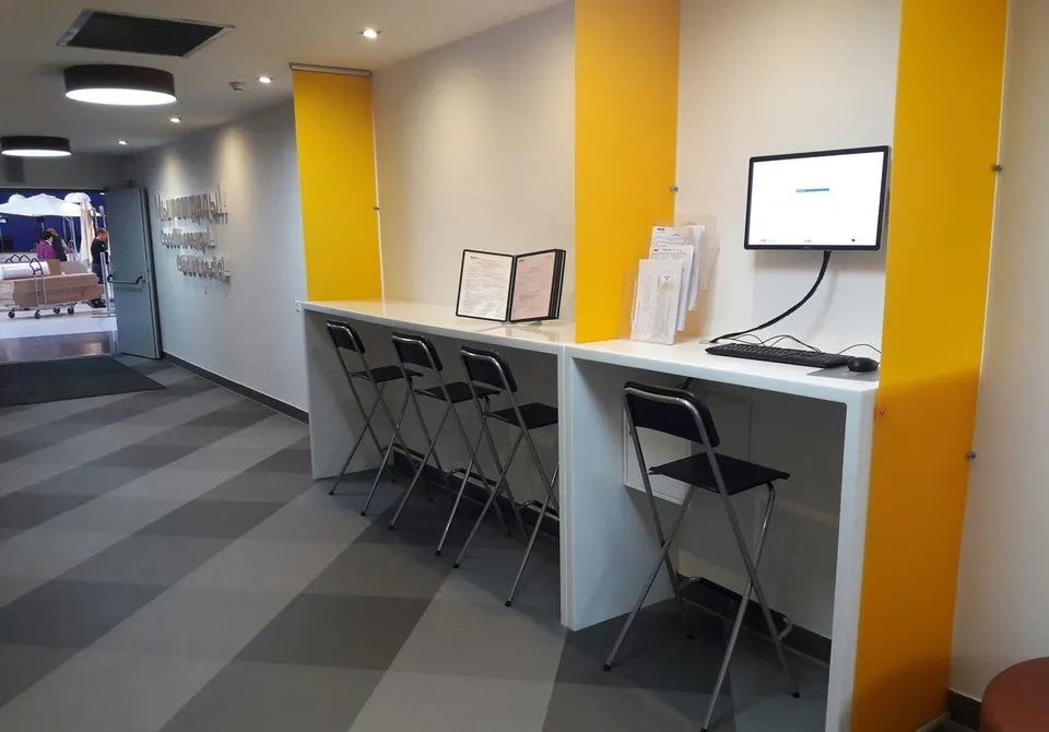 Row of white solid surface workstations between yellow partitions