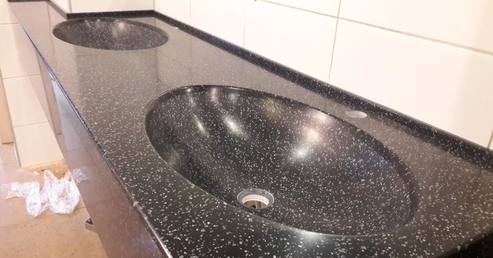 Integrated black speckled solid surface basin in a washroom vanity