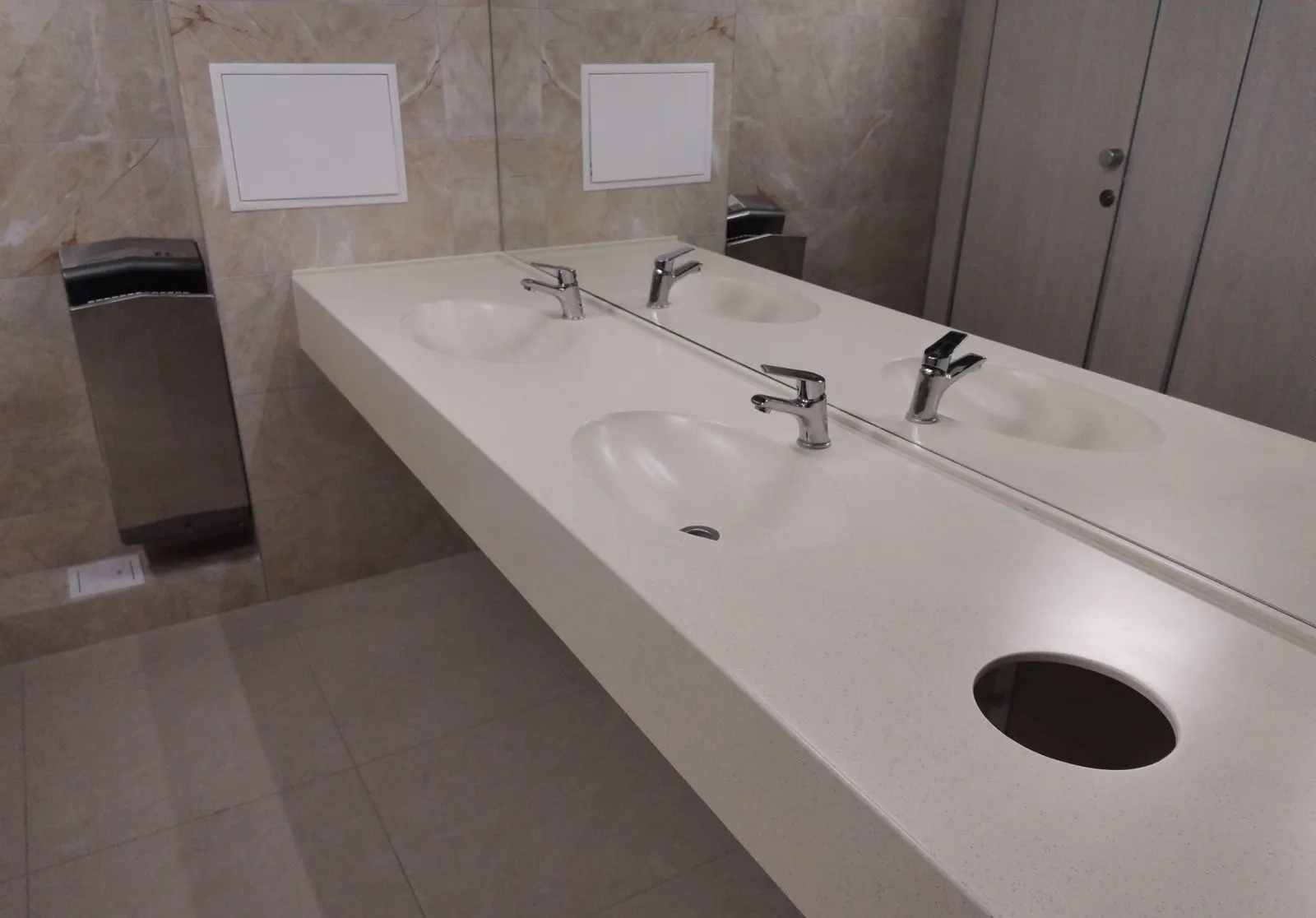 Public washroom vanity with three integrated basins in A209 Aurora solid surface