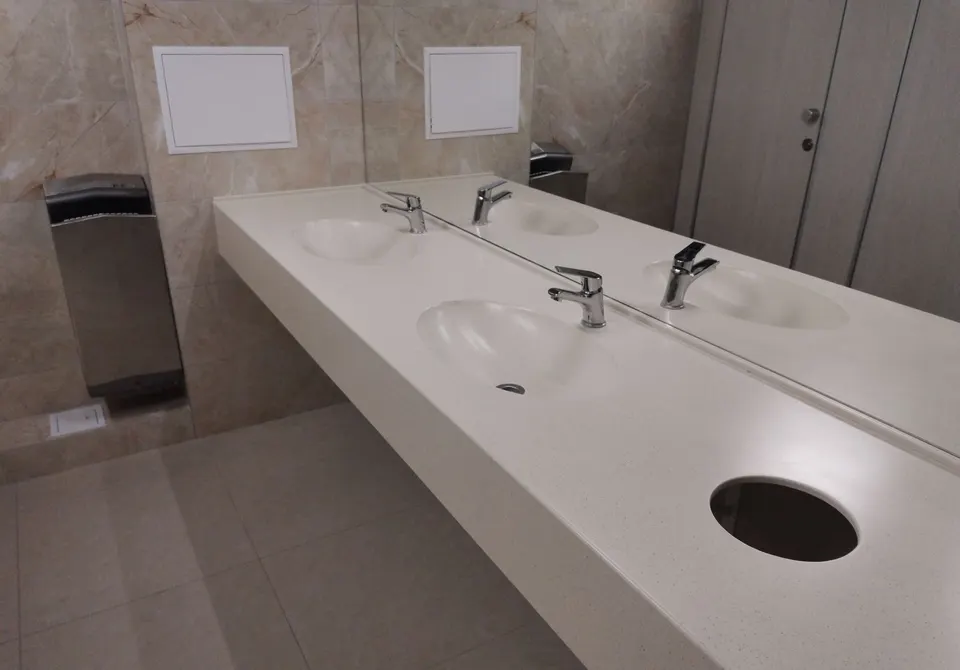 Public washroom vanity with three integrated basins in A209 Aurora solid surface