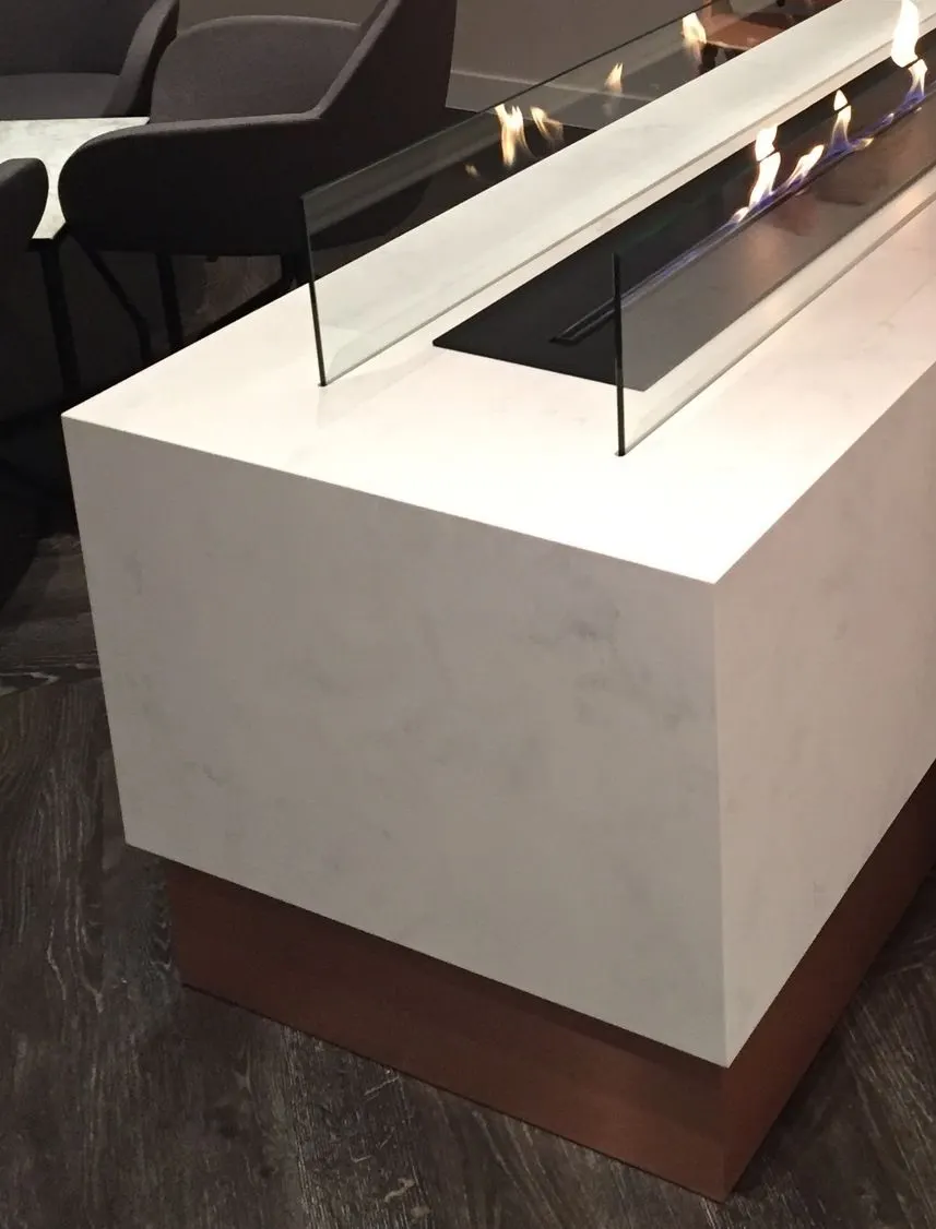 Restaurant table in white veined solid surface with an integrated bioethanol fireplace