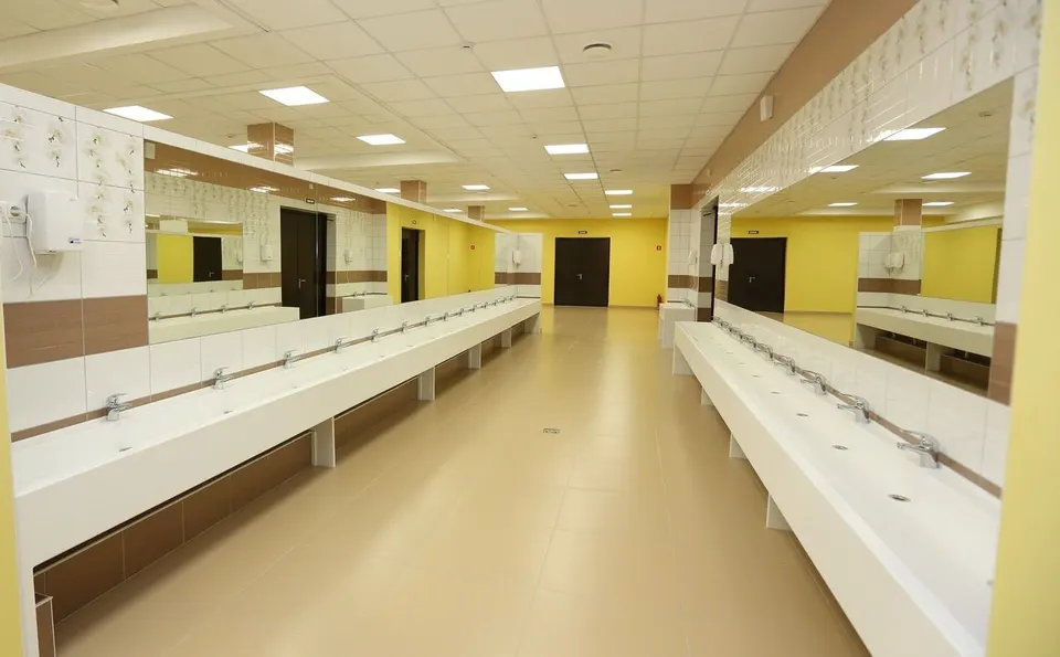 Long rows of wall-hung solid surface basins in a school washroom