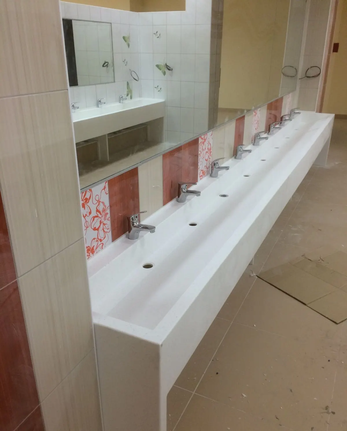 Multi-tap white solid surface trough basin during installation