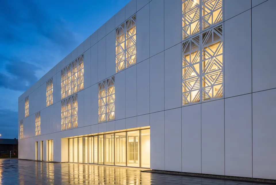 3D visualisation: building facade clad in white solid surface panels with perforated backlit sections